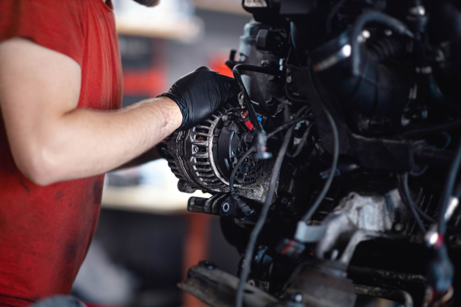 A man is working on a car engine in a garage.