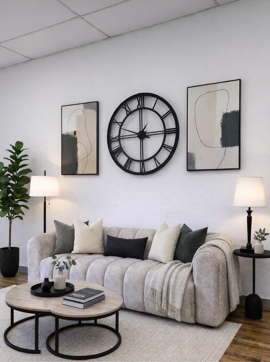 Salón moderno de color beige con sofá, mesa de centro redonda, reloj de pared, cuadro y lámpara de pie.