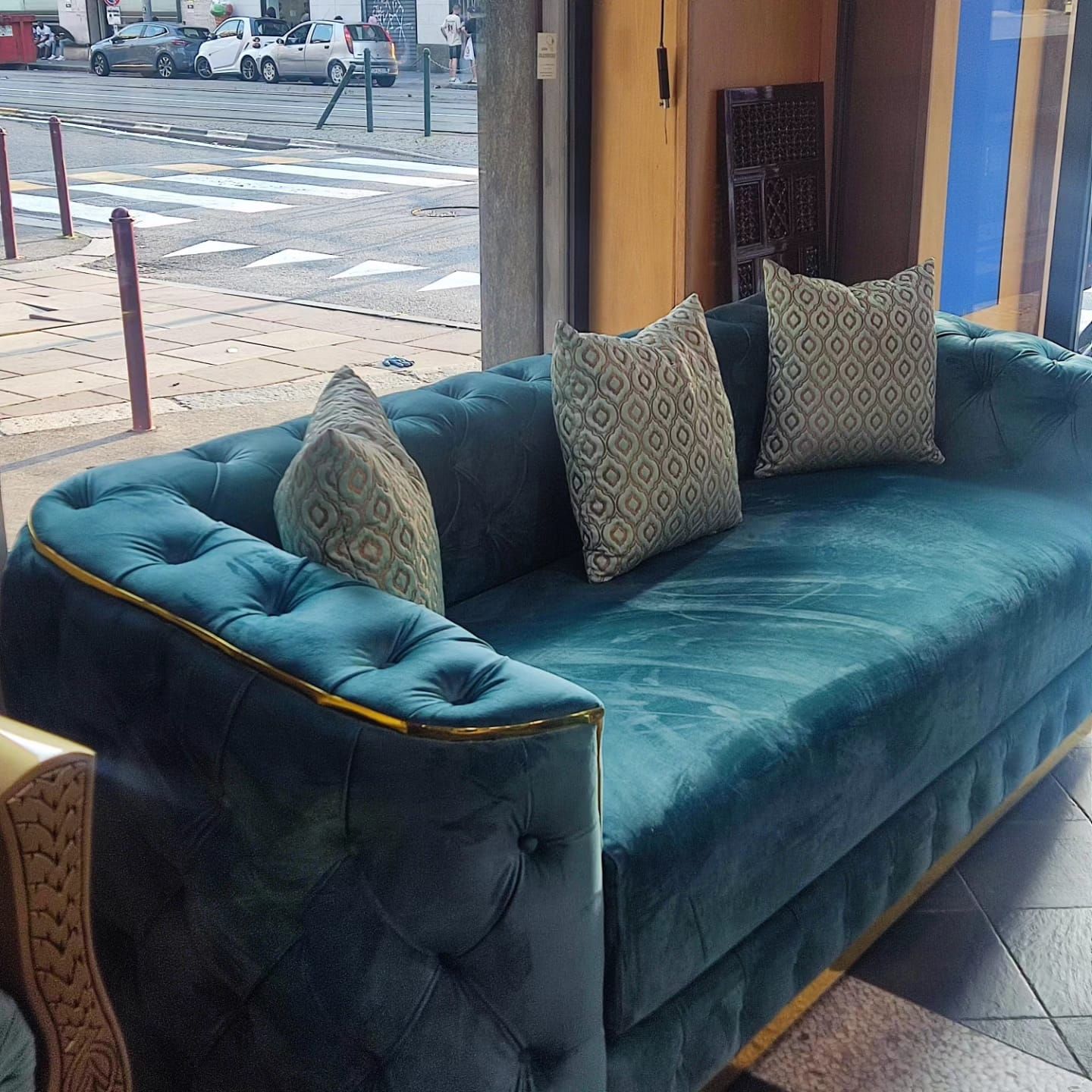 Un divano blu con dei cuscini davanti a una finestra