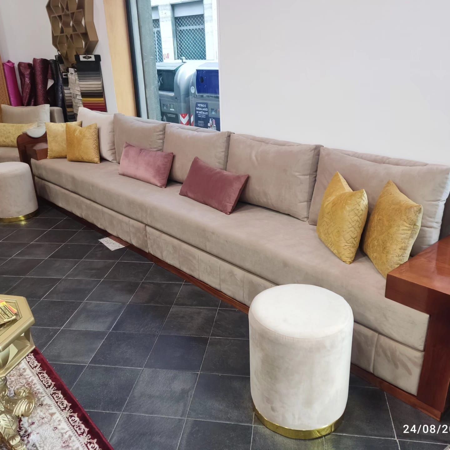 Un soggiorno con un lungo divano e pouf