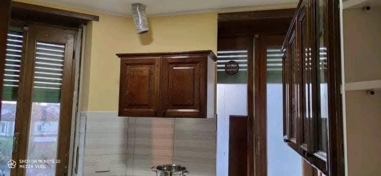 Una cucina con mobili in legno ed elettrodomestici in acciaio inossidabile.