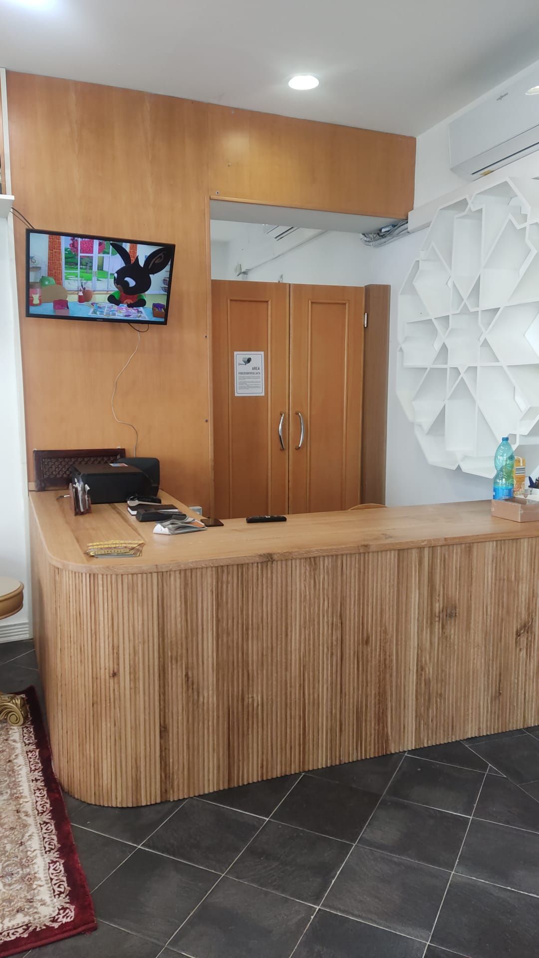 Un bancone di legno in una stanza con una televisione sulla parete.