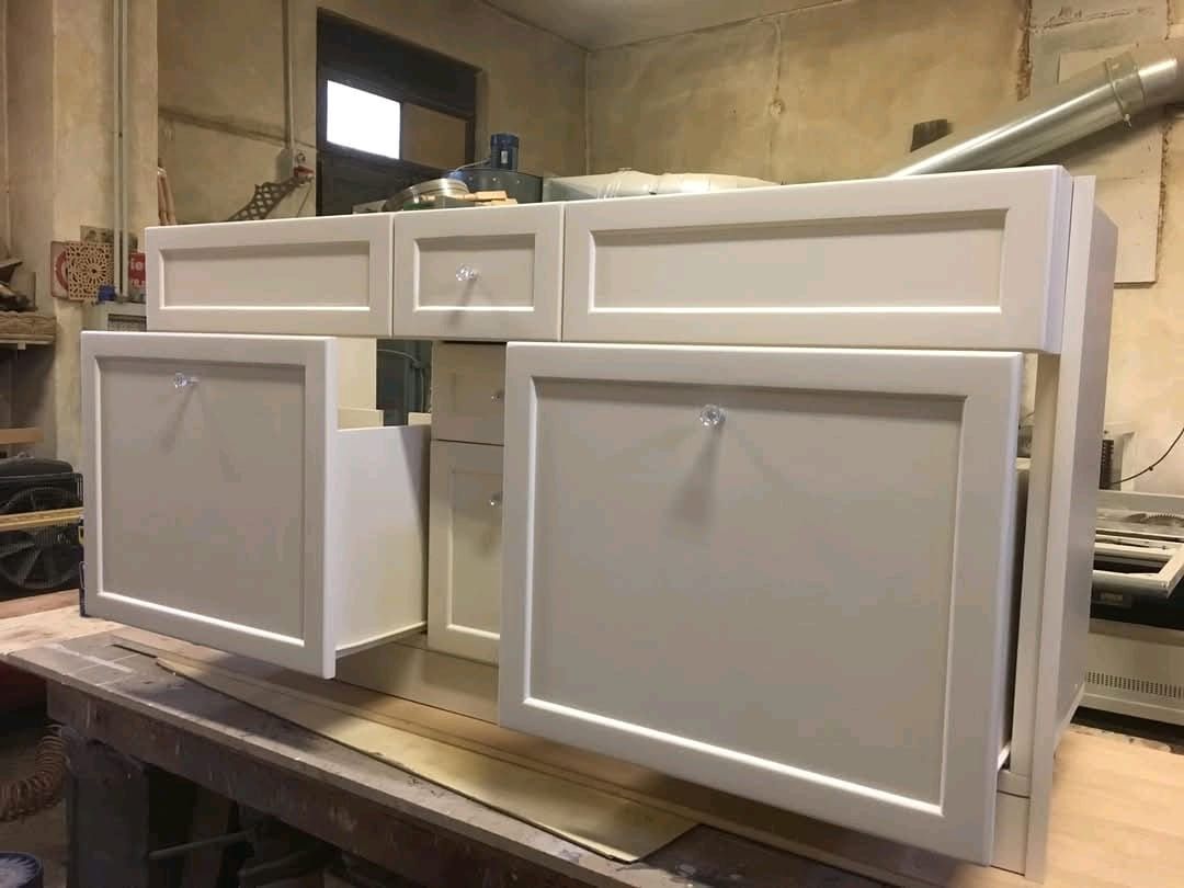 Un mobiletto bianco è appoggiato su un tavolo di legno.