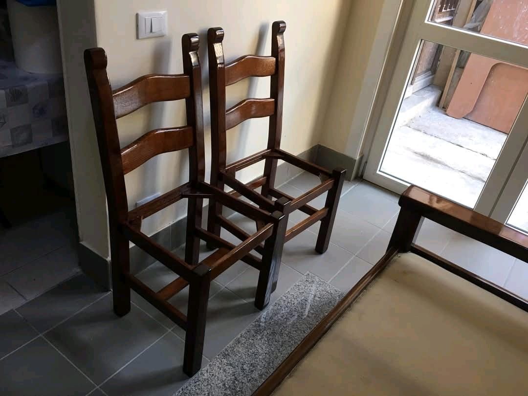 Due sedie di legno sono sedute una accanto all'altra in una stanza