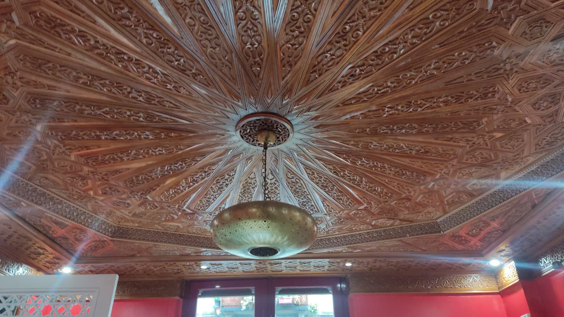 Un soffitto in legno con un lampadario appeso in una stanza.