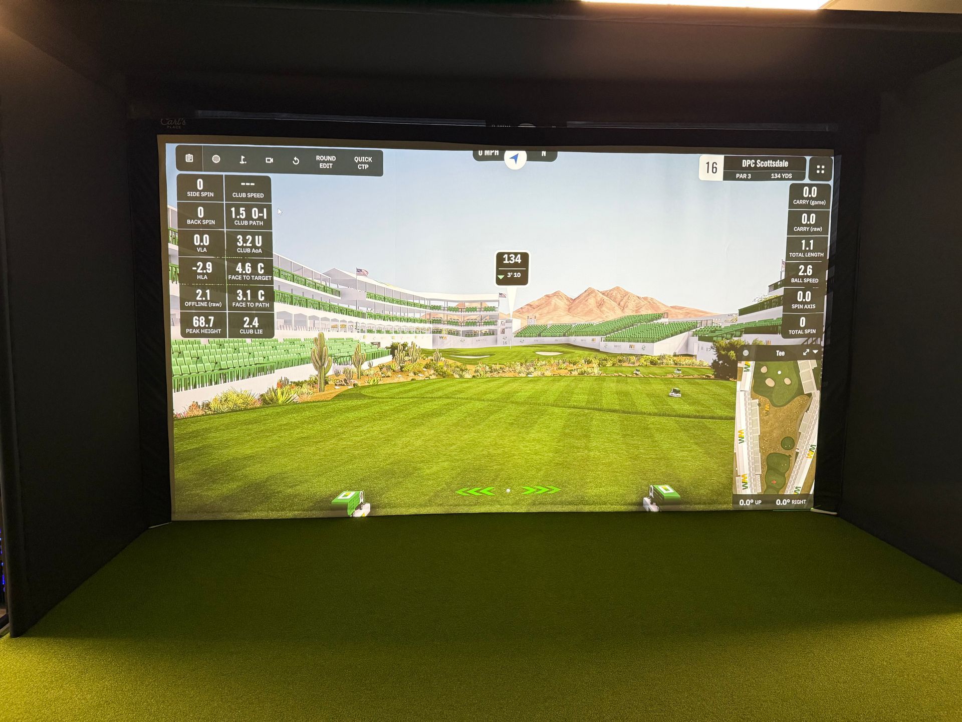 A golf simulator with a large screen displaying a golf course.