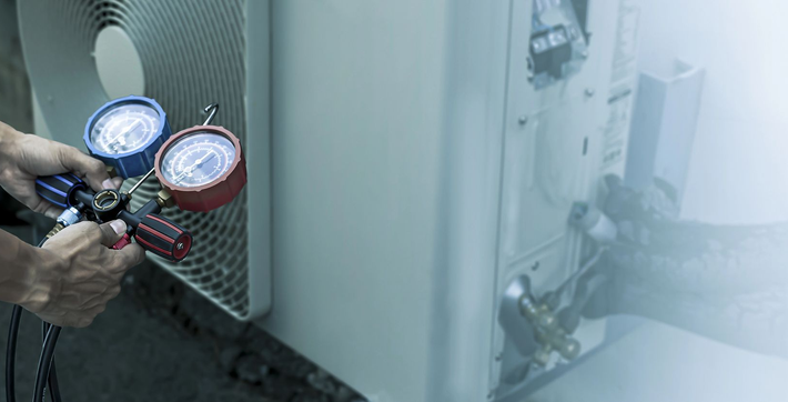 Mani che reggono indicatori blu e rossi collegati ad apparecchiature in un ambiente industriale nebbioso