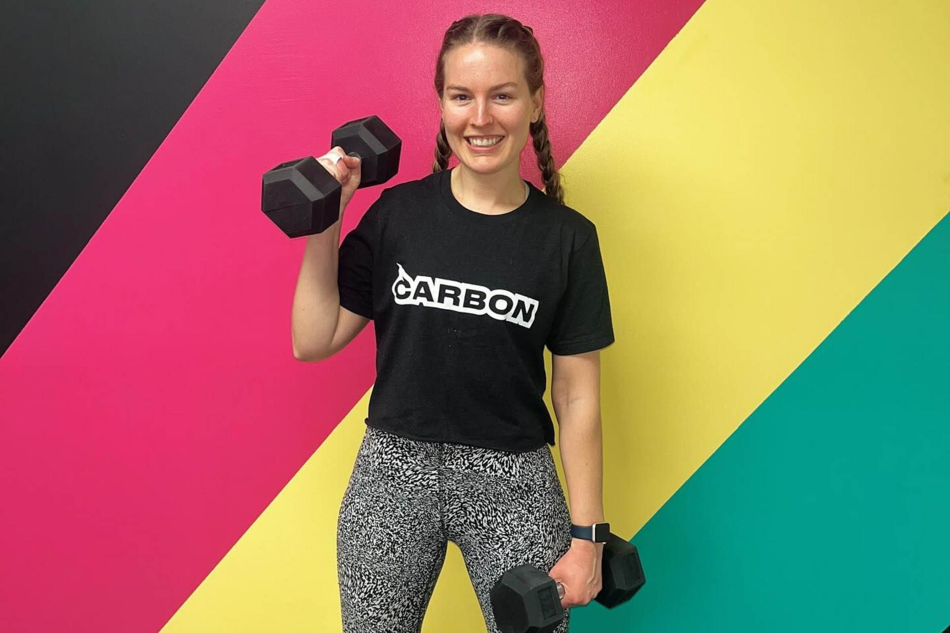 Woman in activewear doing Pilates on reformer machine in a bright studio.