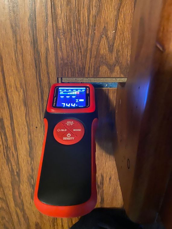 A red and black measuring device is sitting on a wooden table