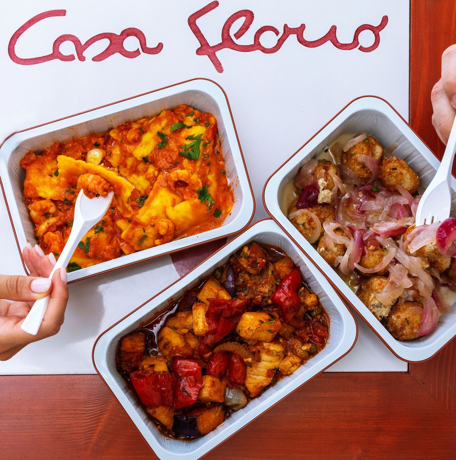 un tavolo con tre contenitori di cibo e un cartello che dice casa florio