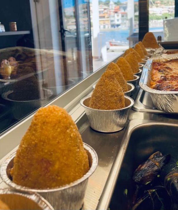 un vassoio di cibo è seduto su un bancone accanto a una finestra .