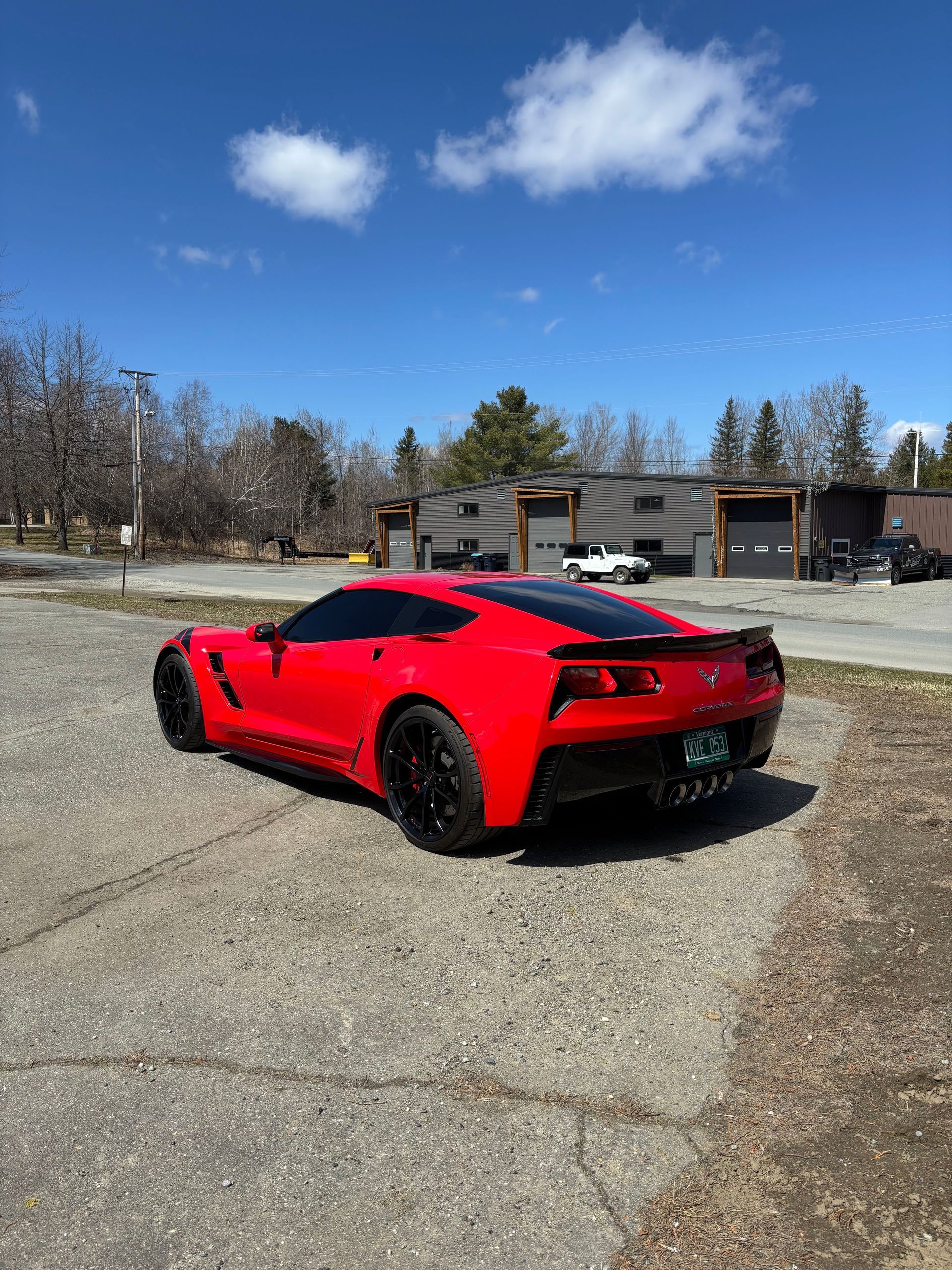 A person is cleaning a blue car with an orange towel