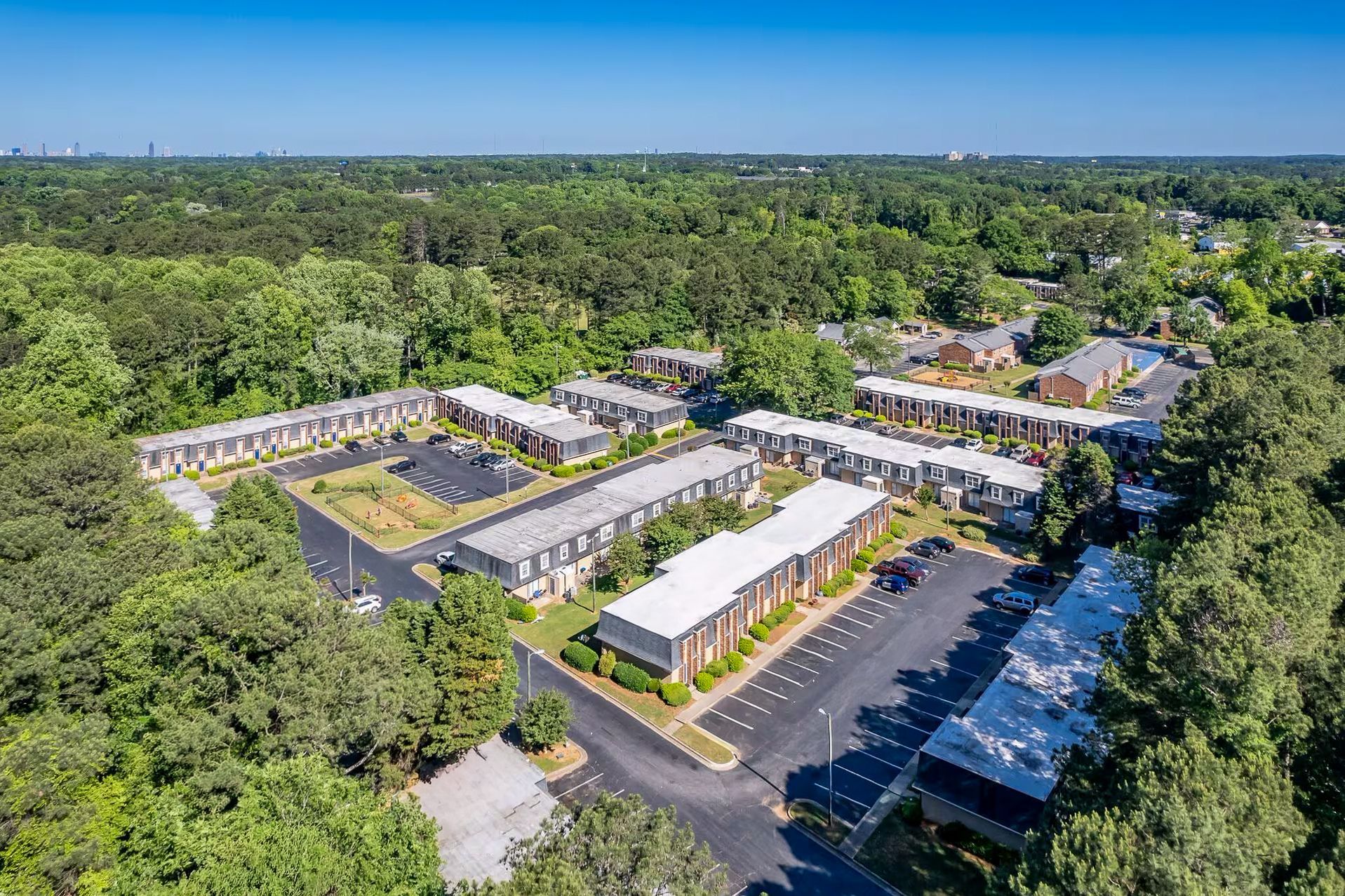 Brick building with white columns, door, and a brick walkway. Green lawn.