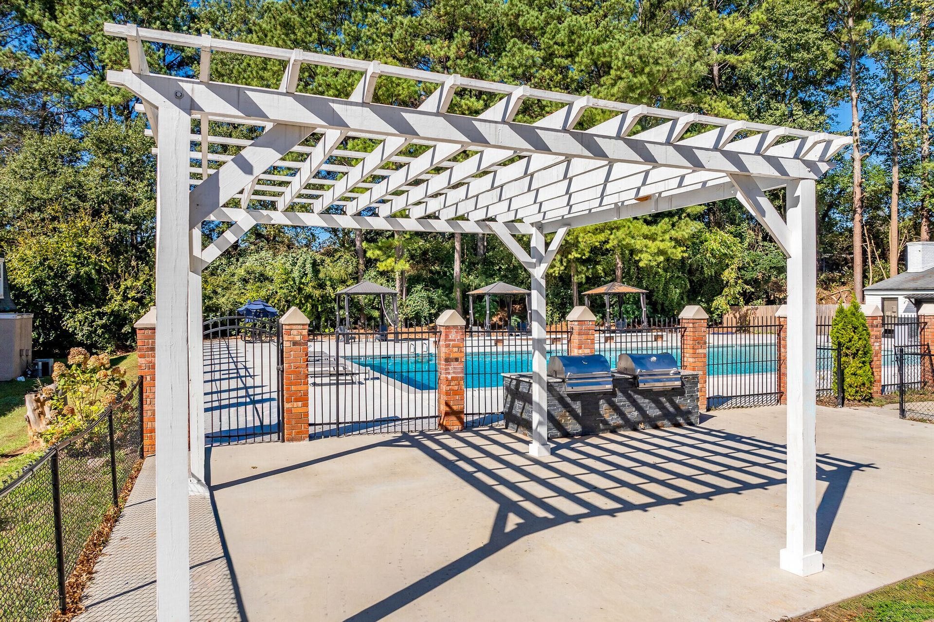 Gray kitchen with black appliances, white subway tile backsplash, and a window.
