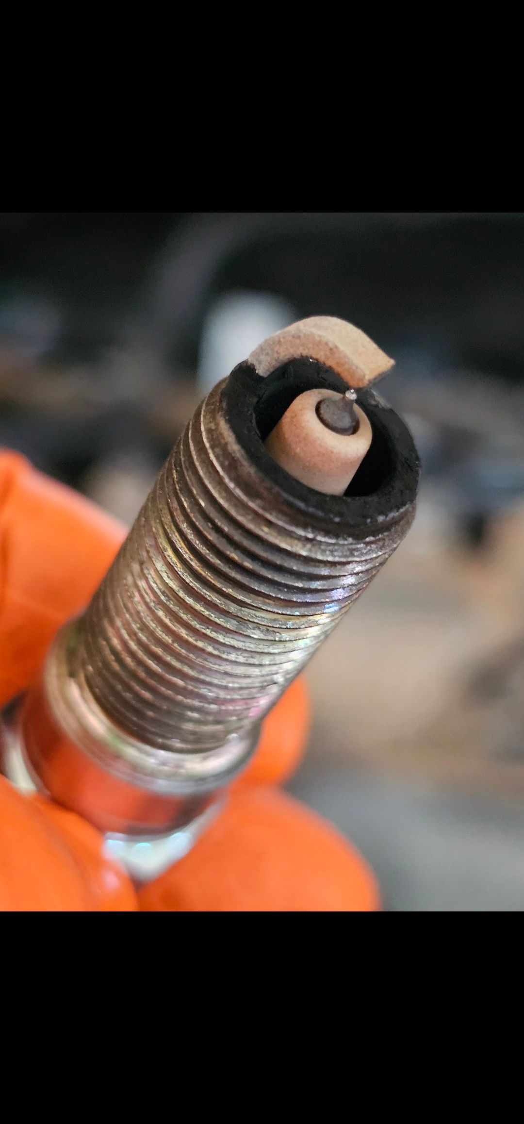 A Person Is Holding a Spark Plug in Their Hand | Fellowship Auto Repair