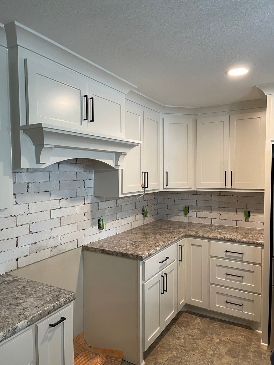 A kitchen with white cabinets and granite counter tops