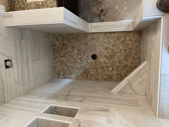 A bathroom with a walk in shower and a sink.