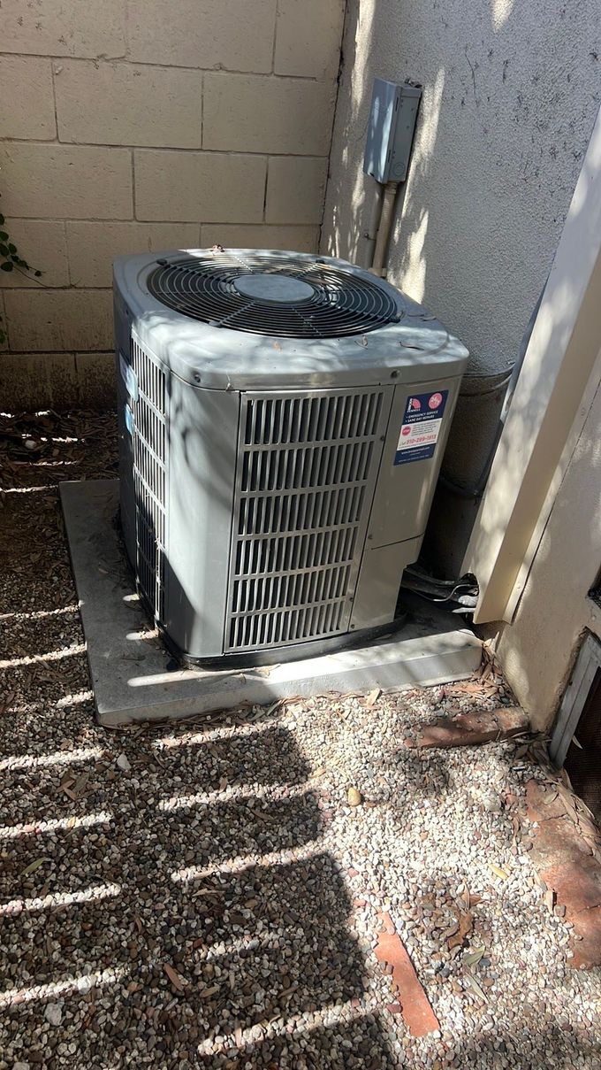 An air conditioner is sitting on the side of a building.