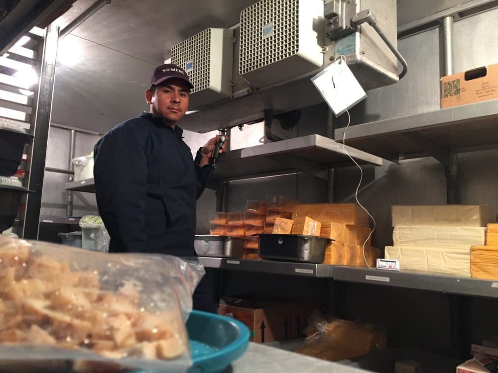 A man is standing in a kitchen looking at something