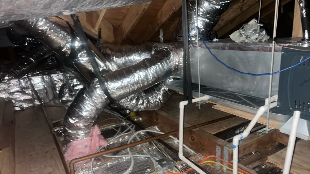 There are a lot of ducts in the attic of a house.