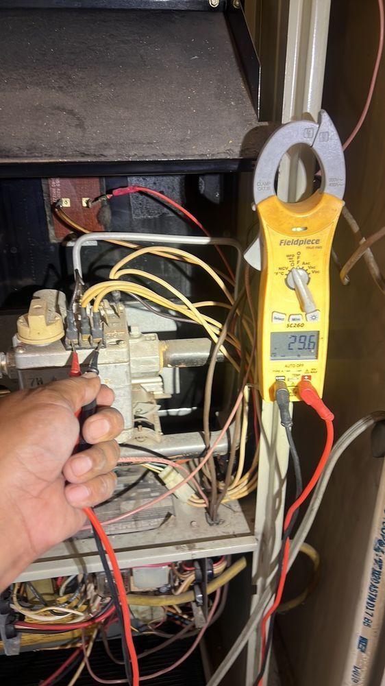 A person is using a clamp meter to test a heater.