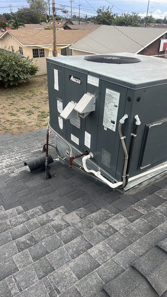 A large air conditioner is sitting on top of a roof.