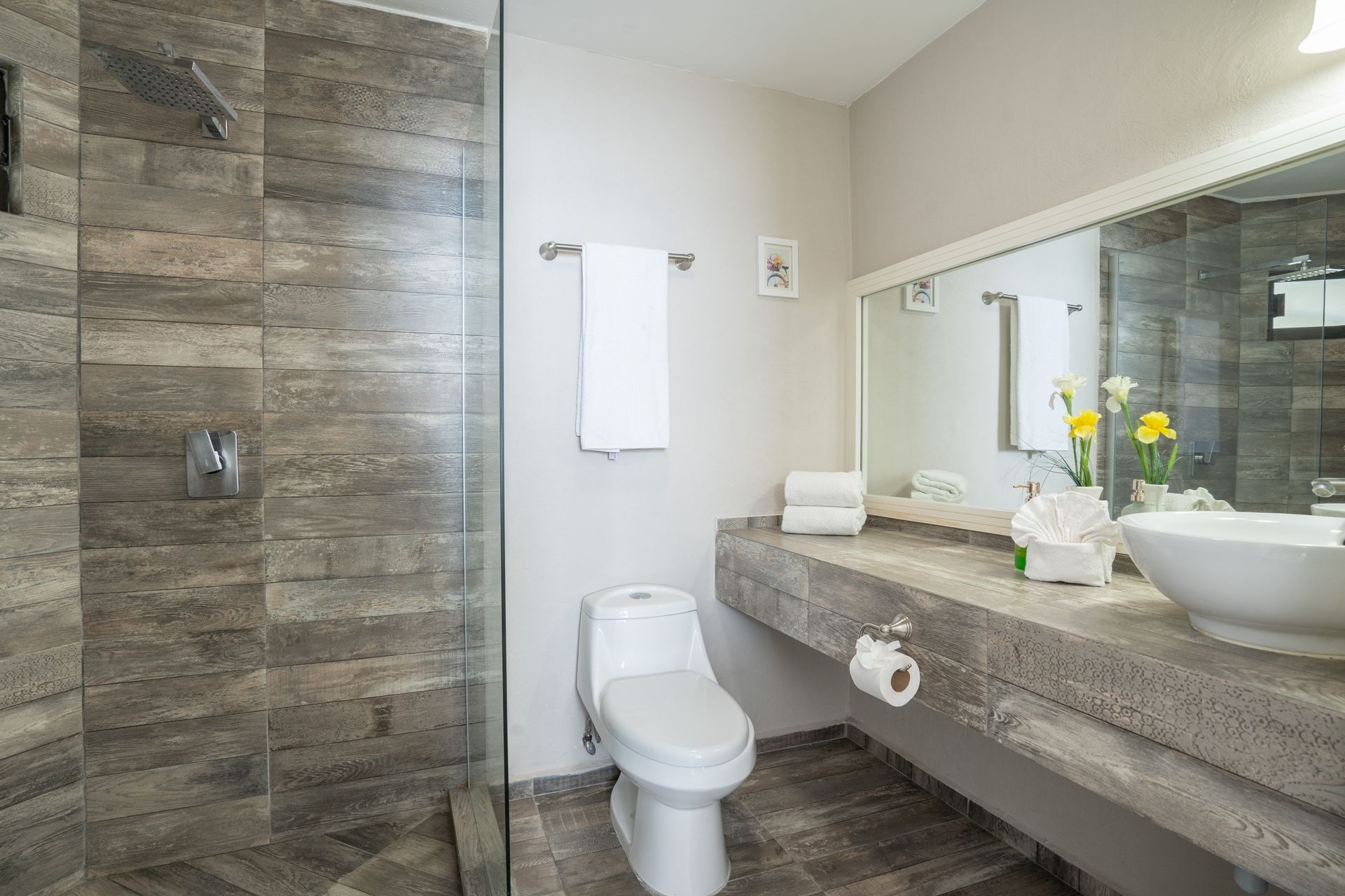 Baño moderno con ducha, inodoro y lavabo. Combinación de colores gris y blanco.