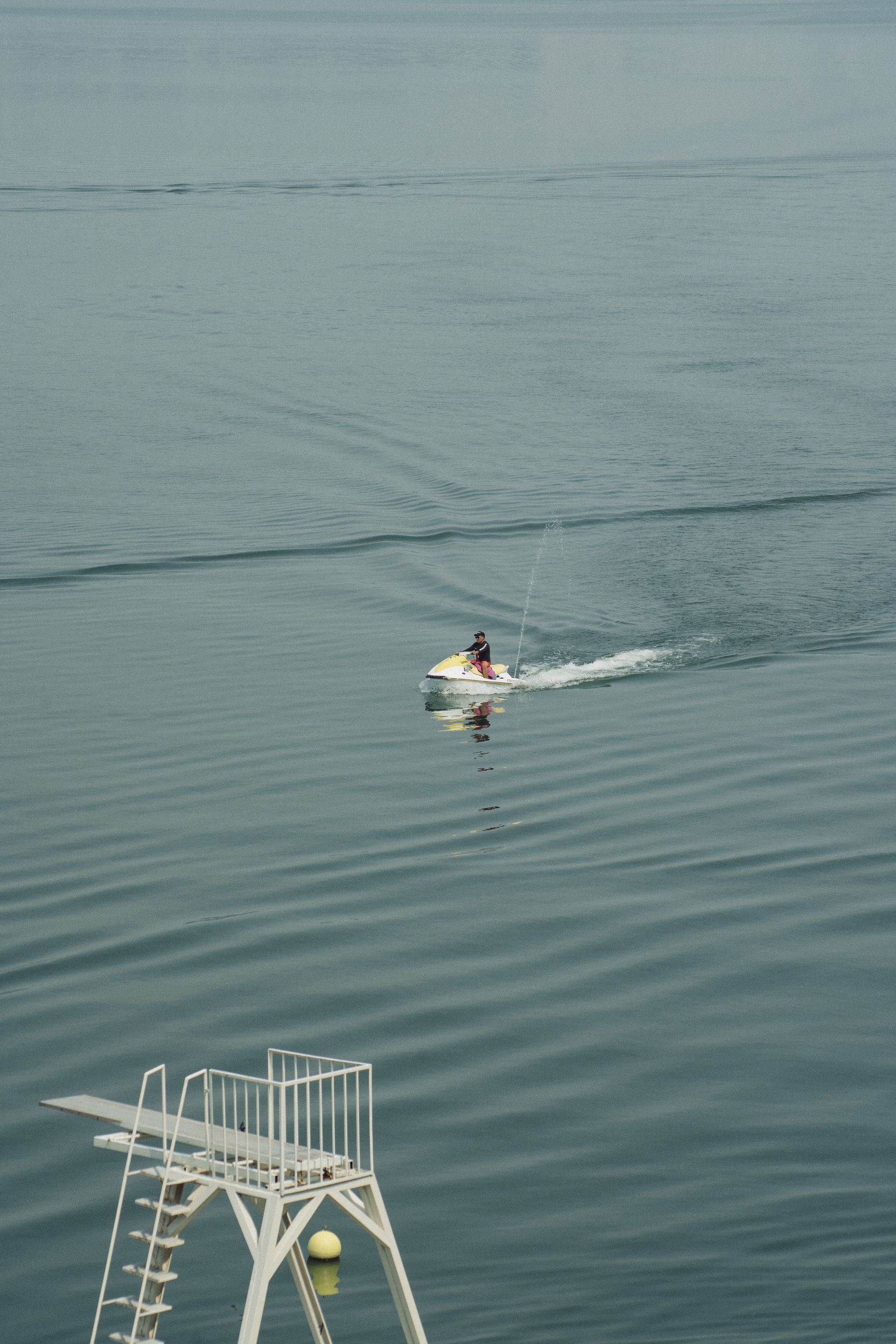 Moto acuática en el agua con un trampolín en primer plano. Agua azul, día soleado.