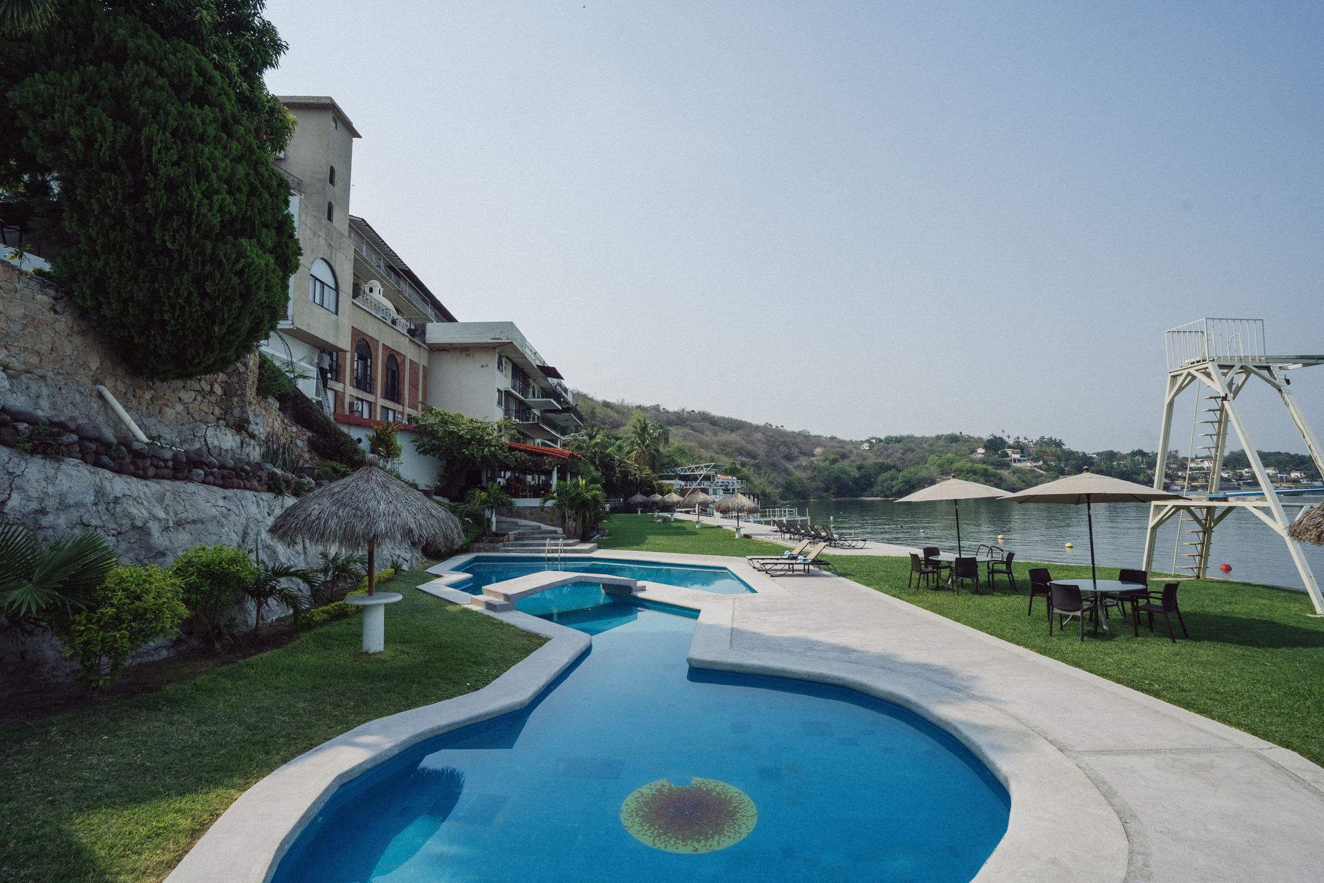 Complejo turístico con piscina y vistas al lago.