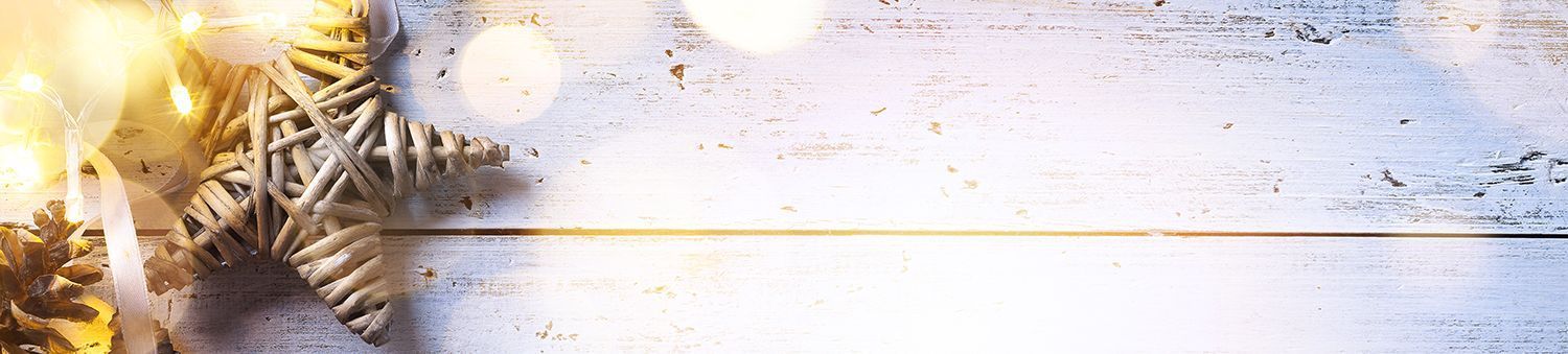 Winter holiday background with pine branches, warm lights, and white wooden planks