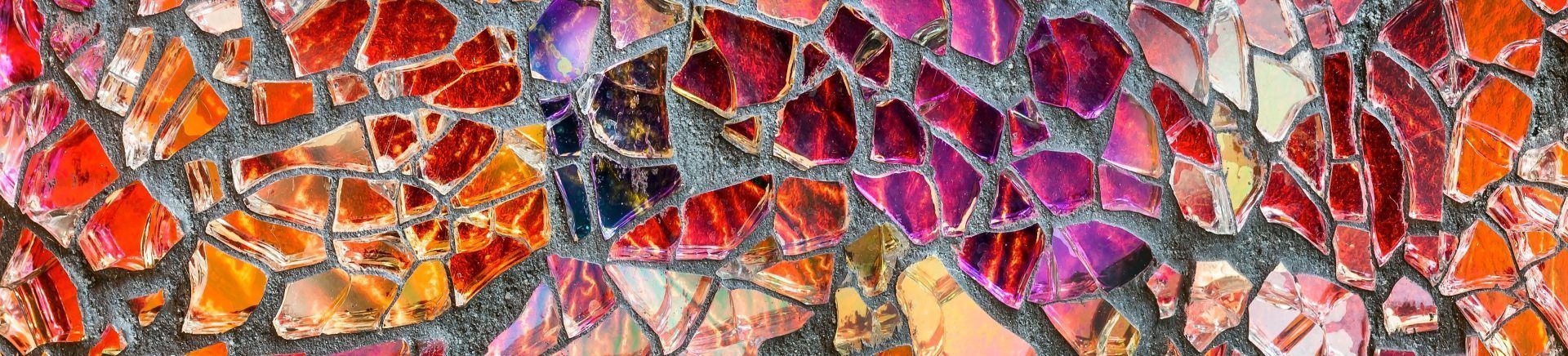 Abstract mosaic of colorful fish scales in orange, red, purple, and yellow tones