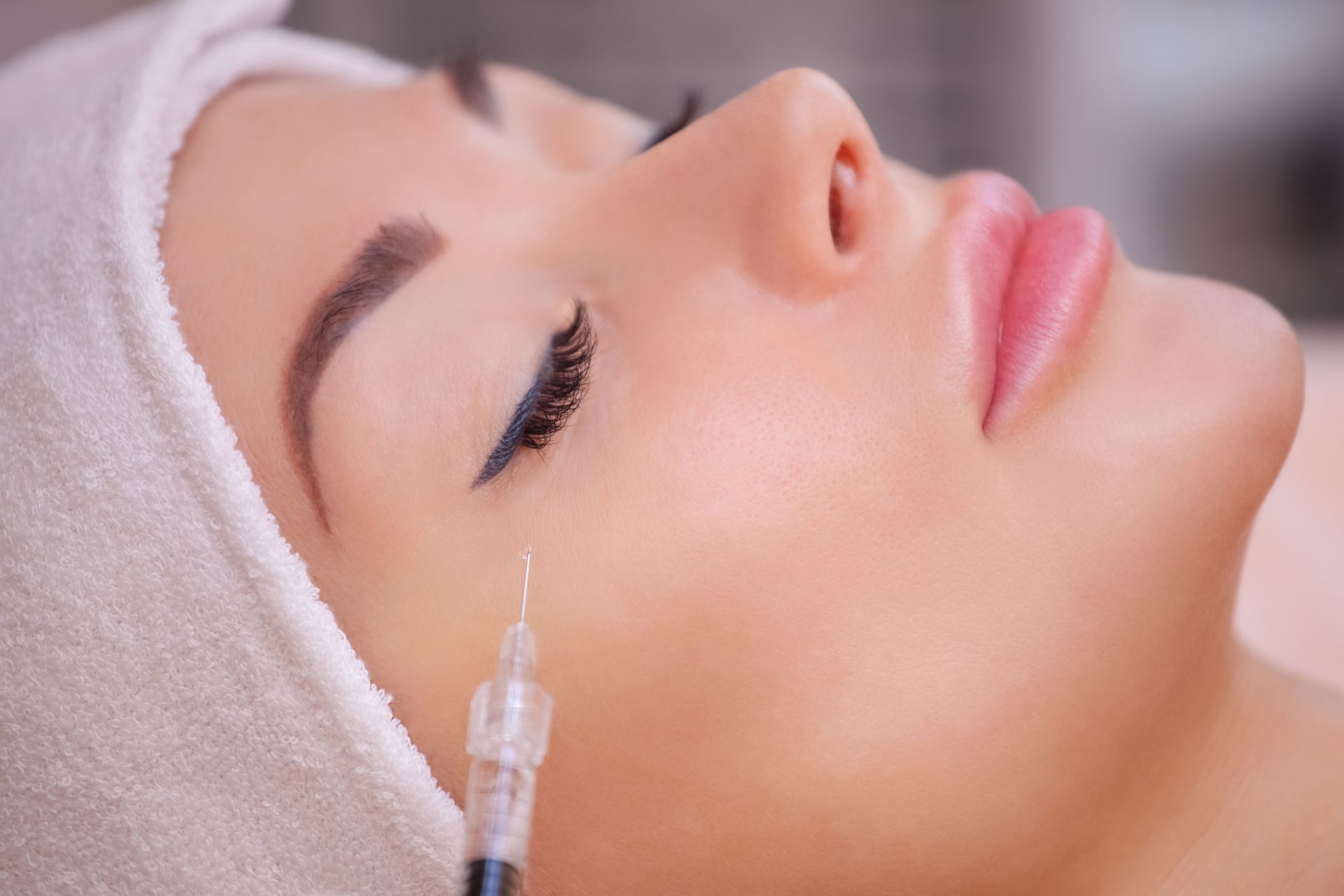 A woman is getting a botox injection in her eye.