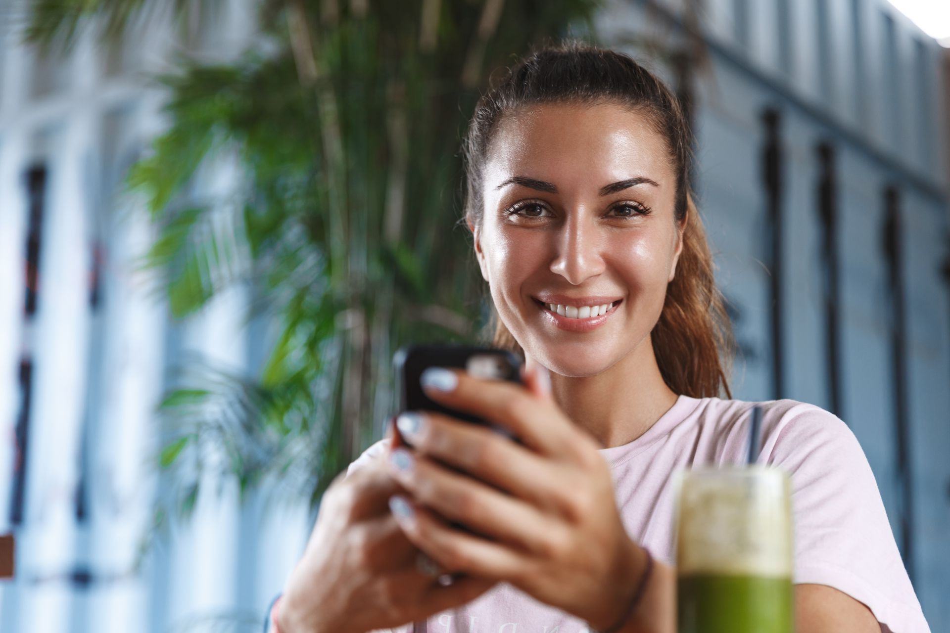 A woman is laying on a couch looking at her phone.