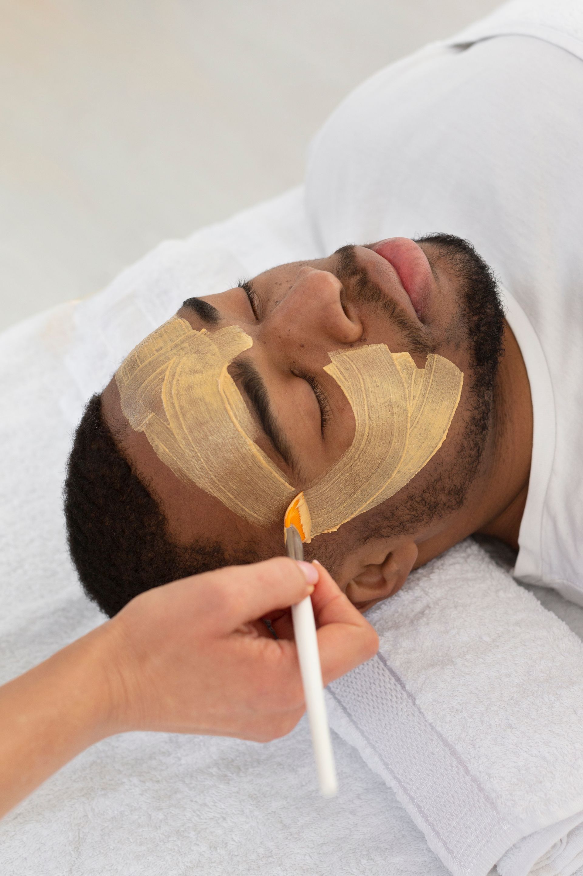 A man is getting a facial treatment at a spa.