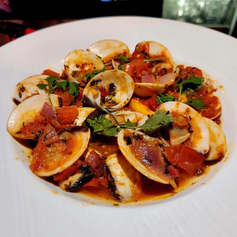 A close up of a plate of food with clams and tomatoes