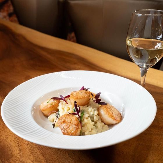 A plate of food next to a glass of wine