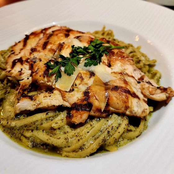 A white plate topped with chicken and noodles