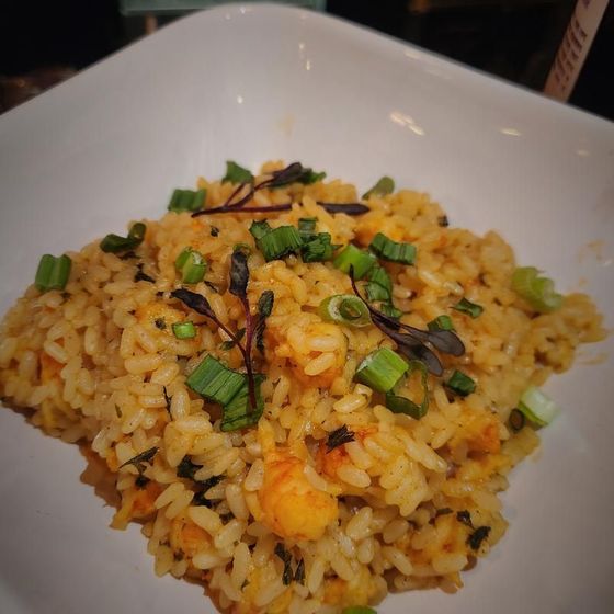 A white plate topped with rice and green onions