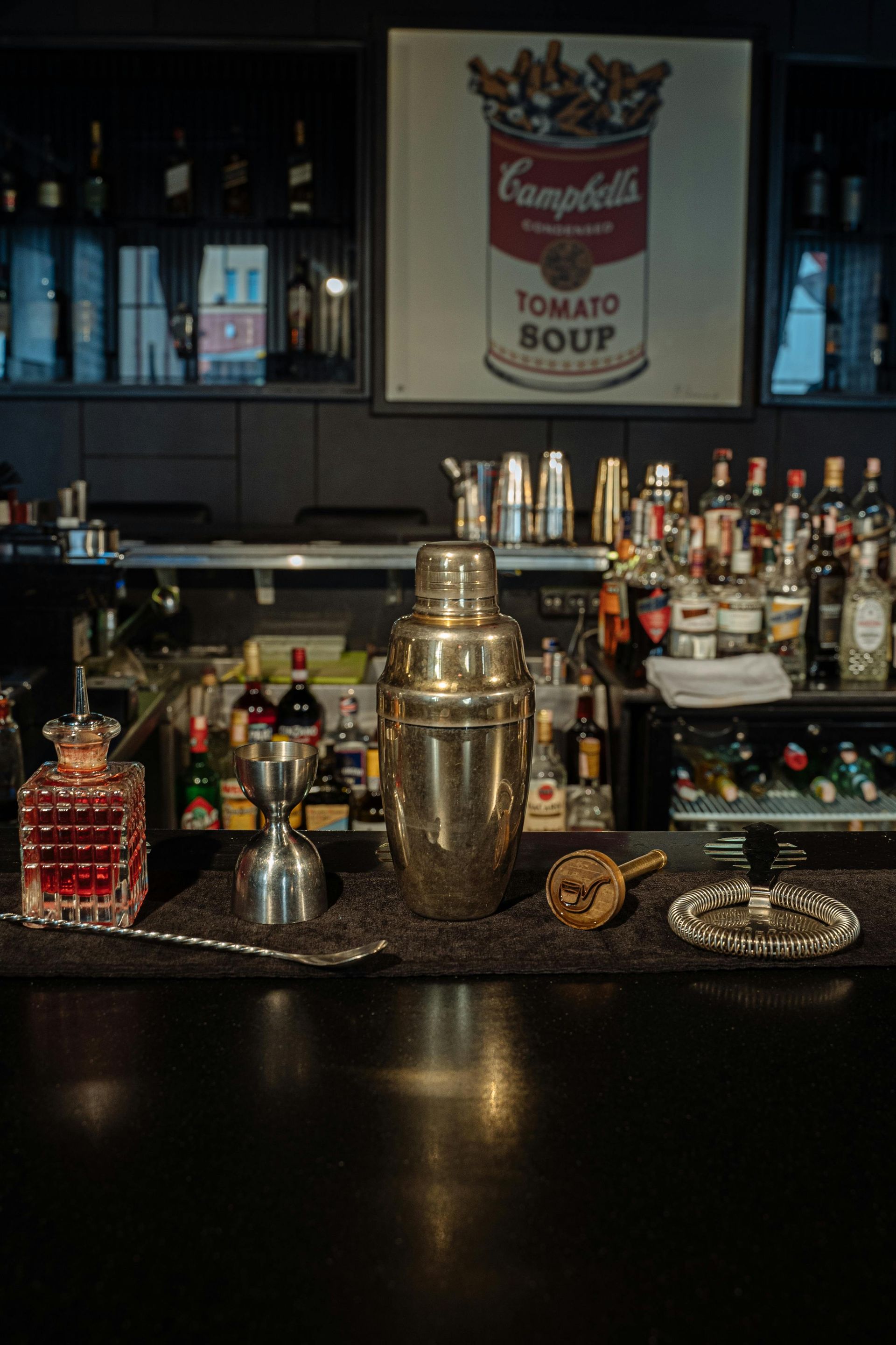A bar with a can of campbell 's tomato soup on the wall.