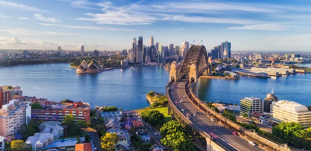 Aerial view of the  Harbour Bridge with the city skyline across the blue water.