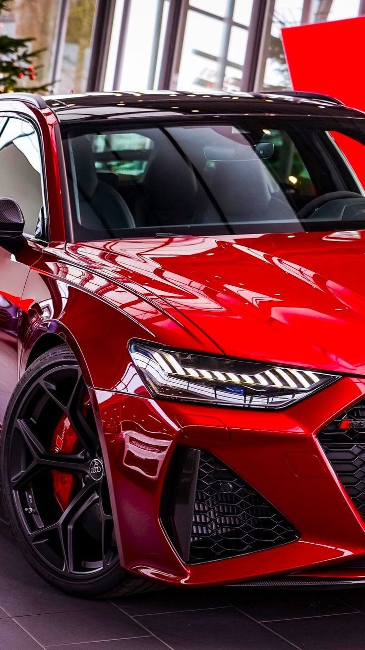 A red audi rs7 is parked in a showroom.