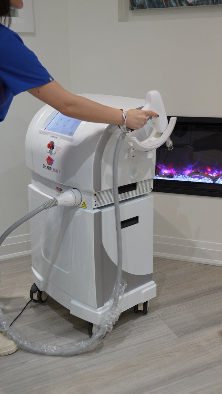 A woman is using a laser hair removal machine in a room.