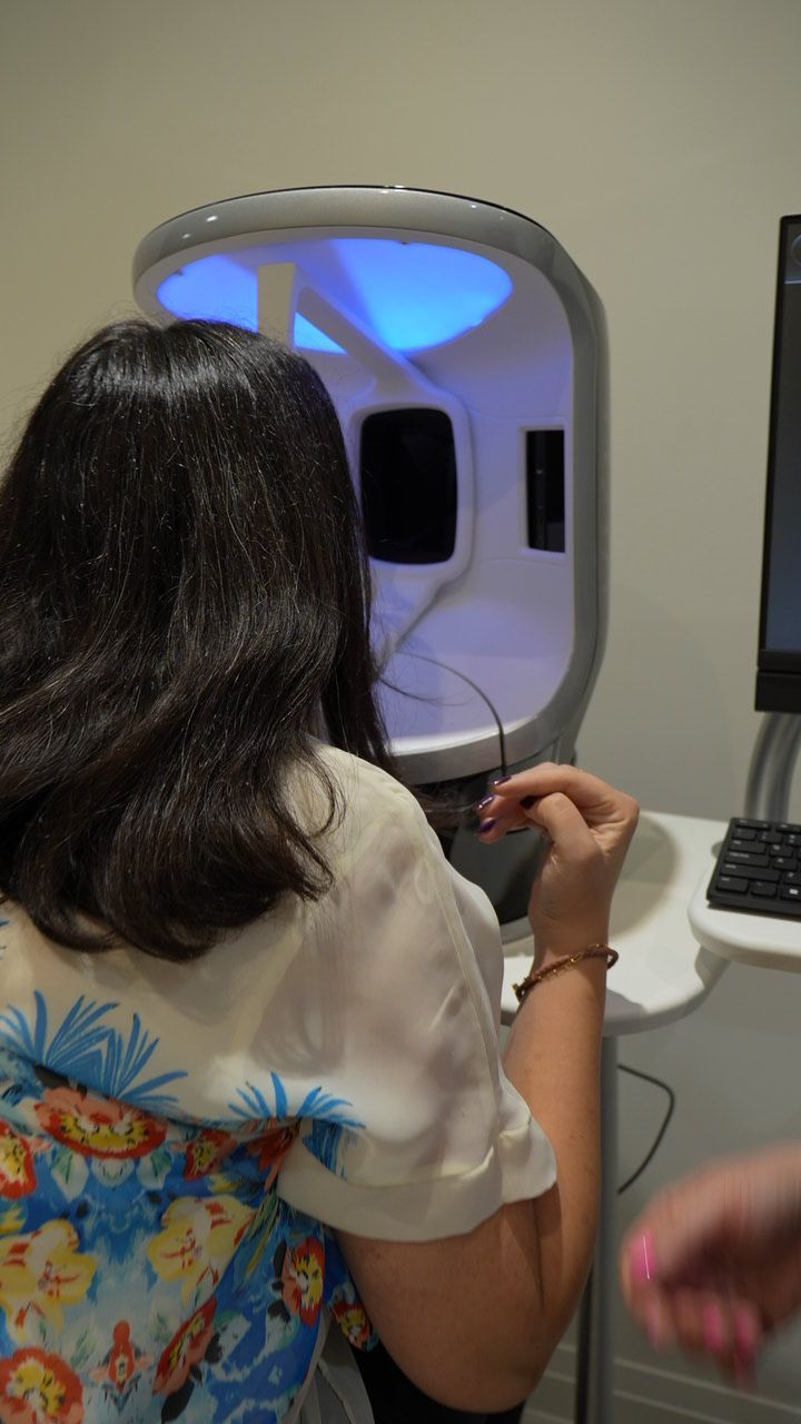 A woman is sitting in front of a computer in a room.