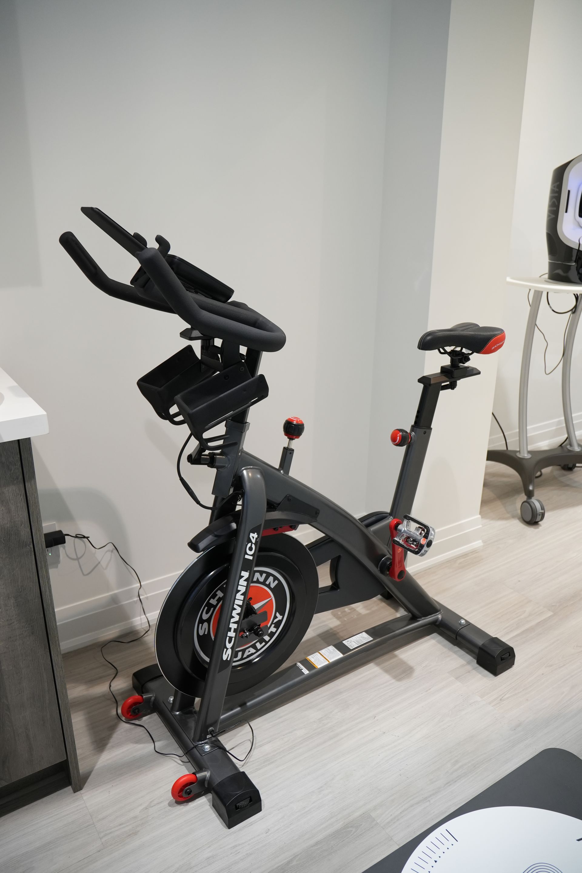 An exercise bike is sitting on a wooden floor in a room.