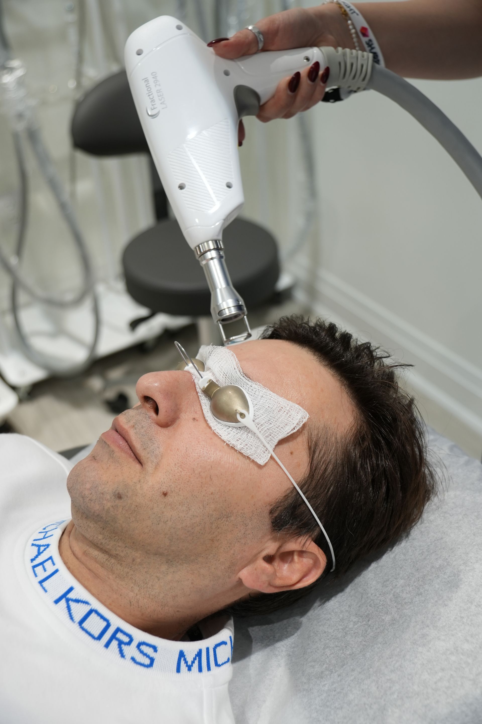 A man is getting a laser treatment on his face.