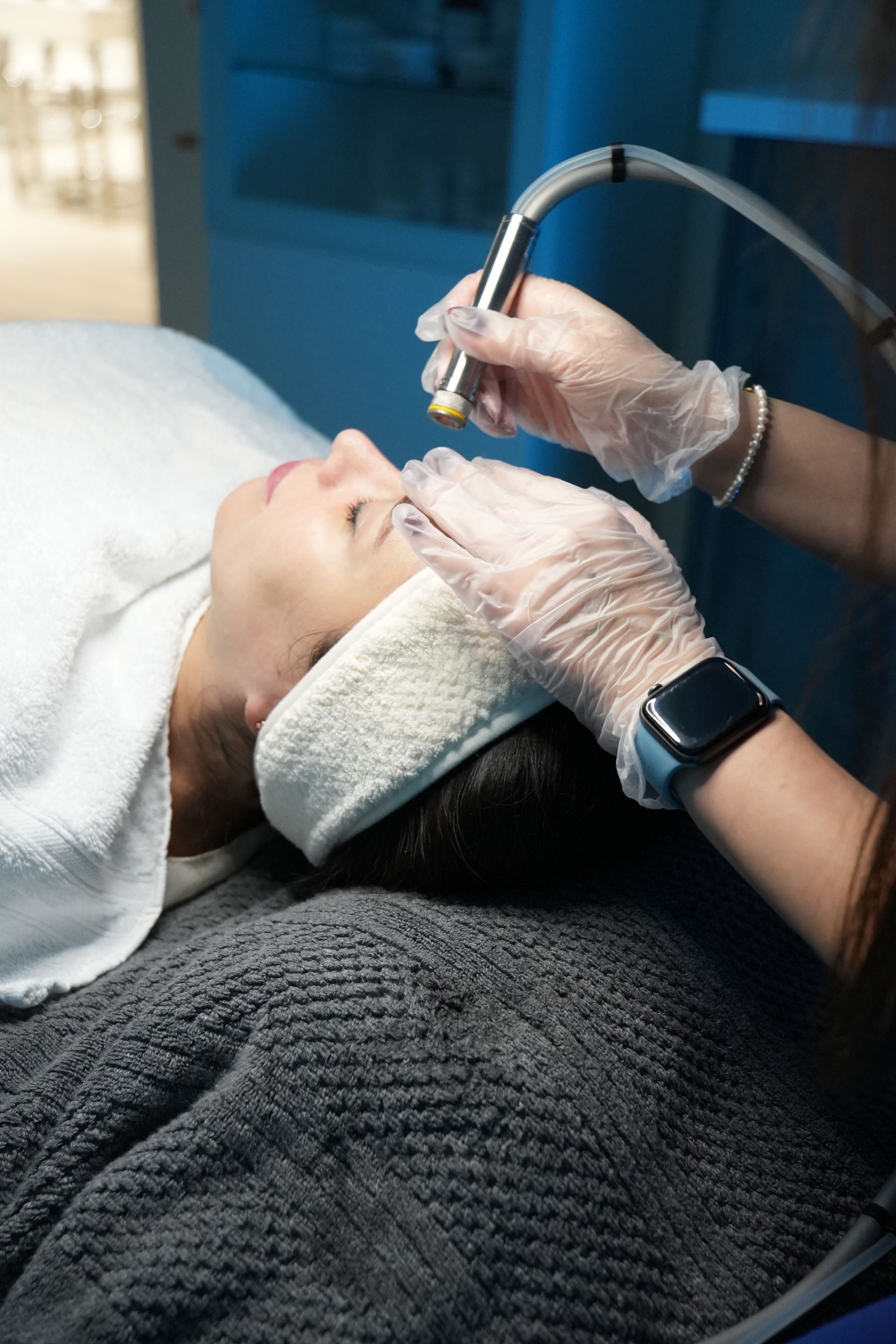 A woman is getting a facial treatment at a beauty salon.