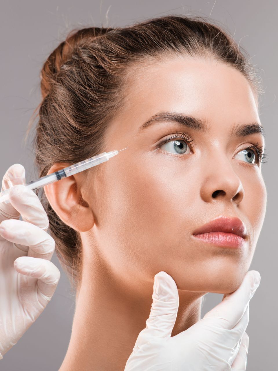 A woman is getting a botox injection in her face.