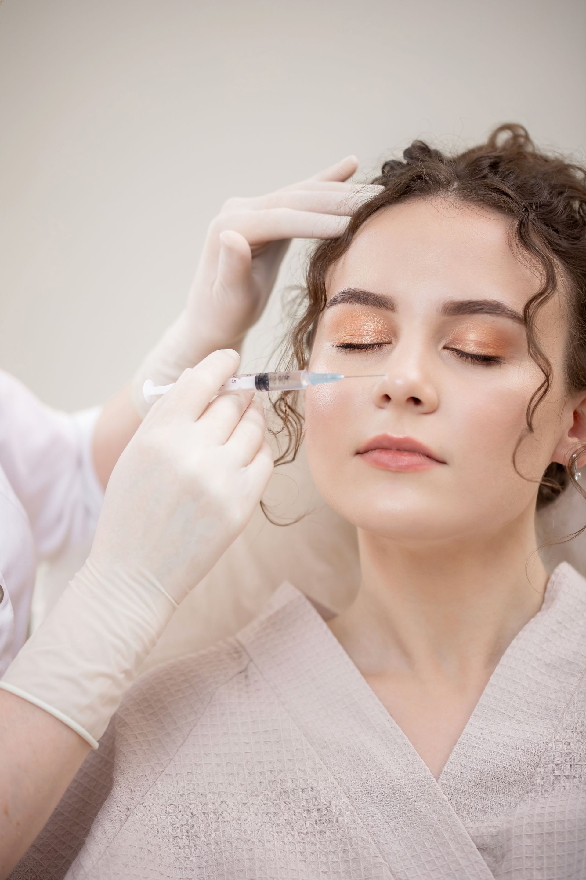 A woman is getting a botox injection in her face.