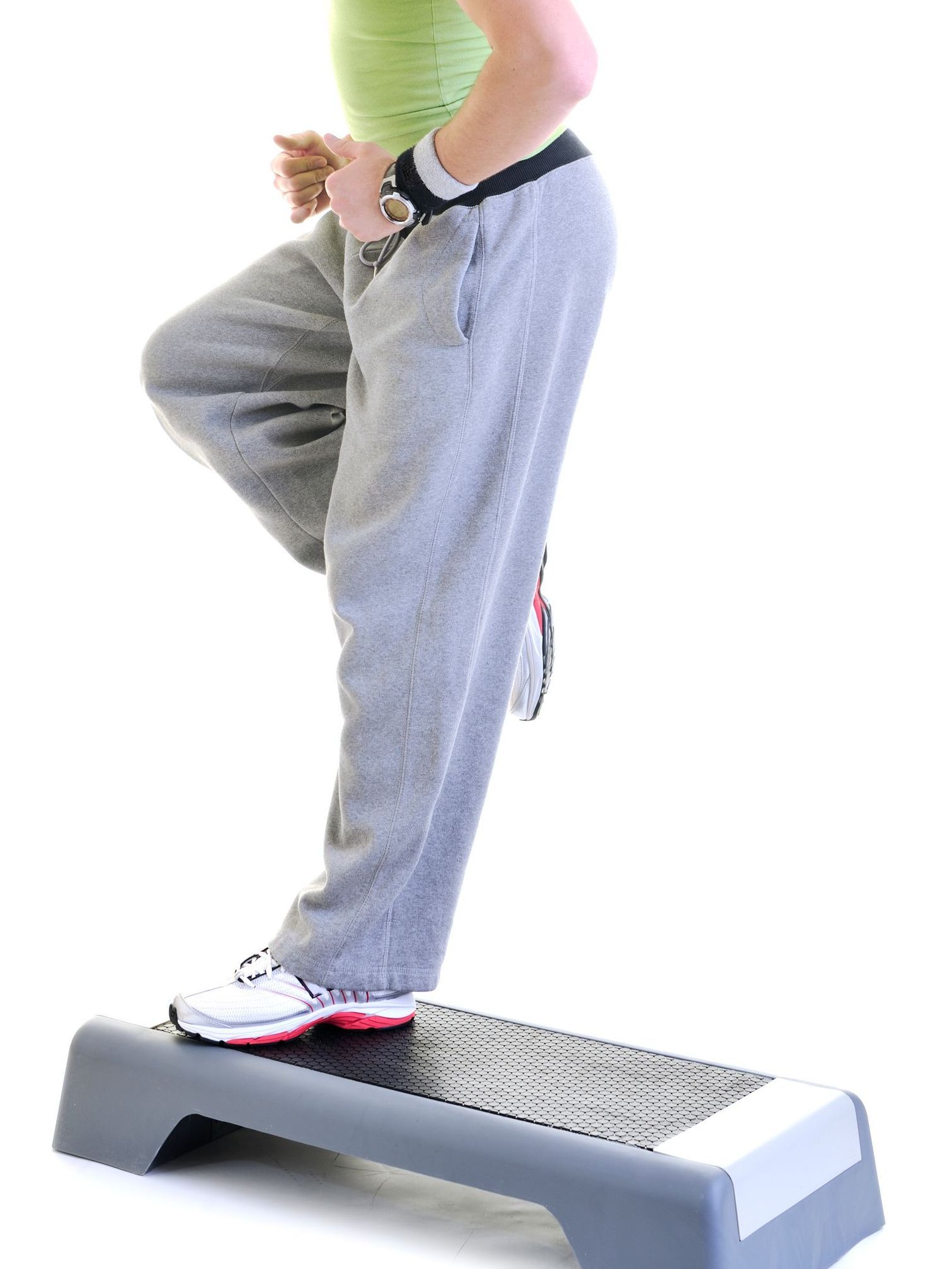 A woman is standing on a stepper with one leg up