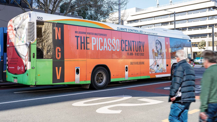 A bus that says the picasso century is parked on the side of the road.